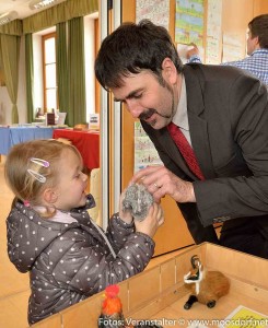 Josef Hangöbl (Cheforganisator der Ausstellung) und eine ganz junge Besucherin, die das Motto der Bibelausstellung, Anfassen der Ausstellungsstücke durchaus erwünscht, gleich in die Tat umsetzte